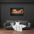 Gray sofa with white blanket and pillows against a dark wall with framed artwork.