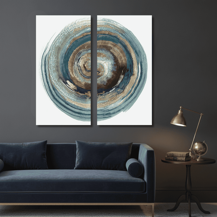 Two-panel abstract spiral wall art in blue and brown tones above a dark blue velvet sofa.