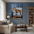 A large vertical canvas print of a cheetah resting on a blue-and-white striped sofa, displayed on a dark blue wall in a styled living room with a sofa, coffee table, and bookcase.